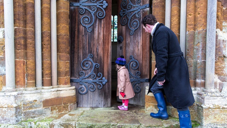 Visitors walking through the church doors at Canons Ashby, Northamptonshire